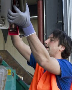 worker-at-a-waste-container-throwing-away-folders.jpg