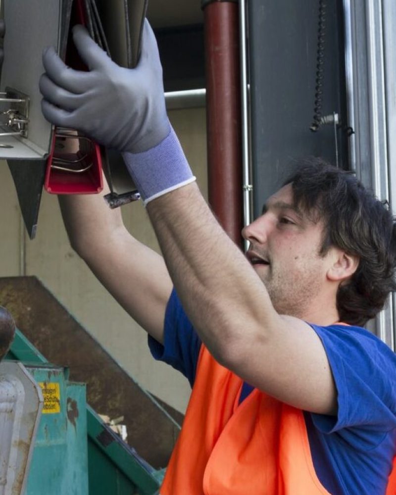 worker-at-a-waste-container-throwing-away-folders.jpg